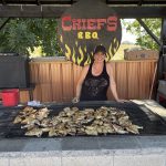 Rachelle at the grill behind chicken cooking