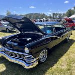 Classic car with hood open to display custom engine